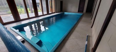 Крытый бассейн с ярко-голубой композитной чашей и панорамным остеклением